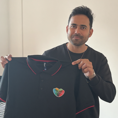 Navdeep, the organiser of our Innovation Day, smiling with a branded hackathon t-shire for our global innovation day.
