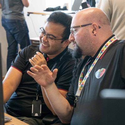 Two male colleagues working and sharing a laugh together at our Innovation Day.